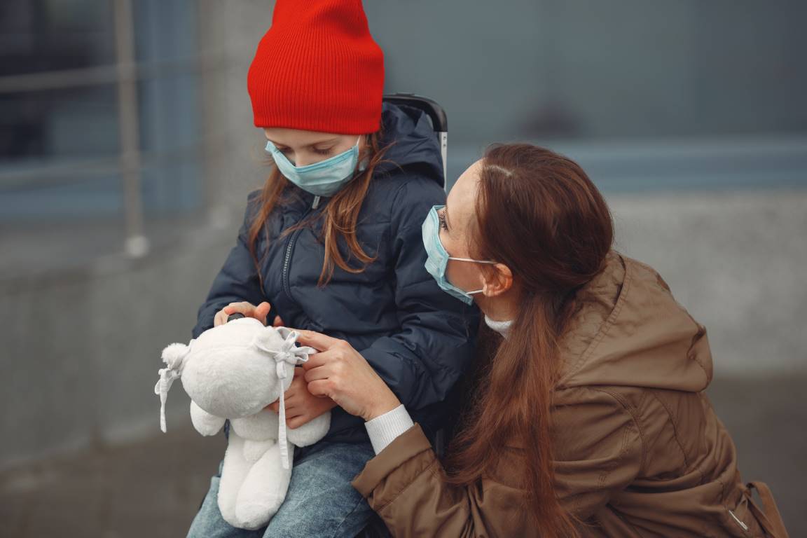 Mujer y niña en la calle con mascarillas Mujer y niña en la calle con mascarillas