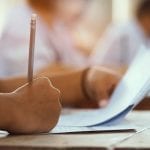 primer-plano-mano-estudiante-sosteniendo-lapiz-tomando-examen-aula-estres-prueba-educacion_73622-731