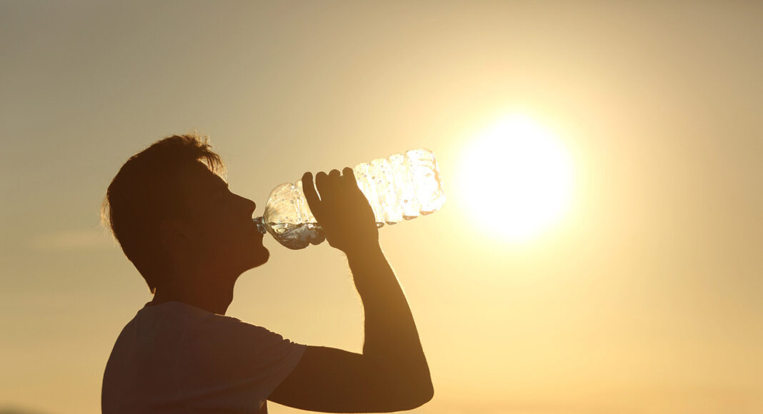 alerta amarilla por calor en euskadi foto de una persona bebiendo agua bajo un sol y calor foto de depositphotos