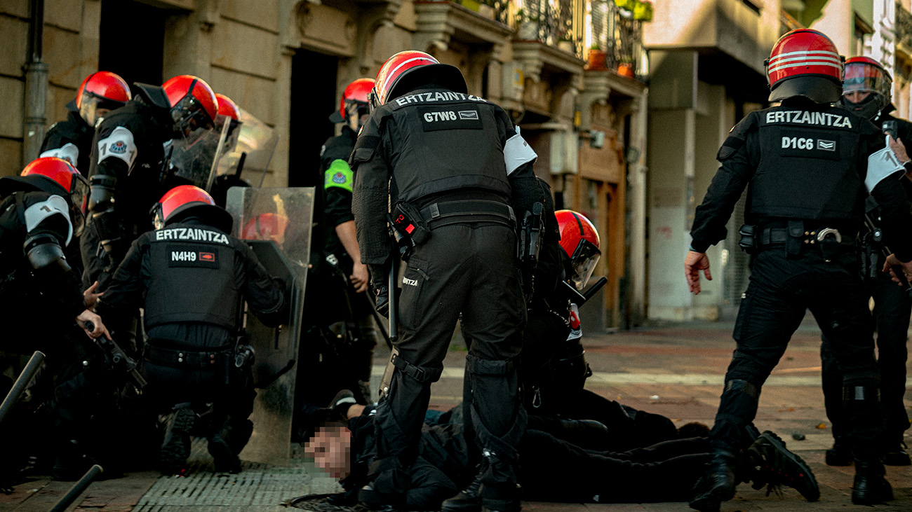 Agentes antidisturbios de la Ertzaintza detienen a dos jóvenes antifascistas durante la concentración de Falange en Vitoria-Gasteiz, el 12 de octubre | Imagen: Mikel Bejarano Agentes antidisturbios de la Ertzaintza detienen a dos jóvenes antifascistas durante la concentración de Falange en Vitoria-Gasteiz, el 12 de octubre | Imagen: Mikel Bejarano