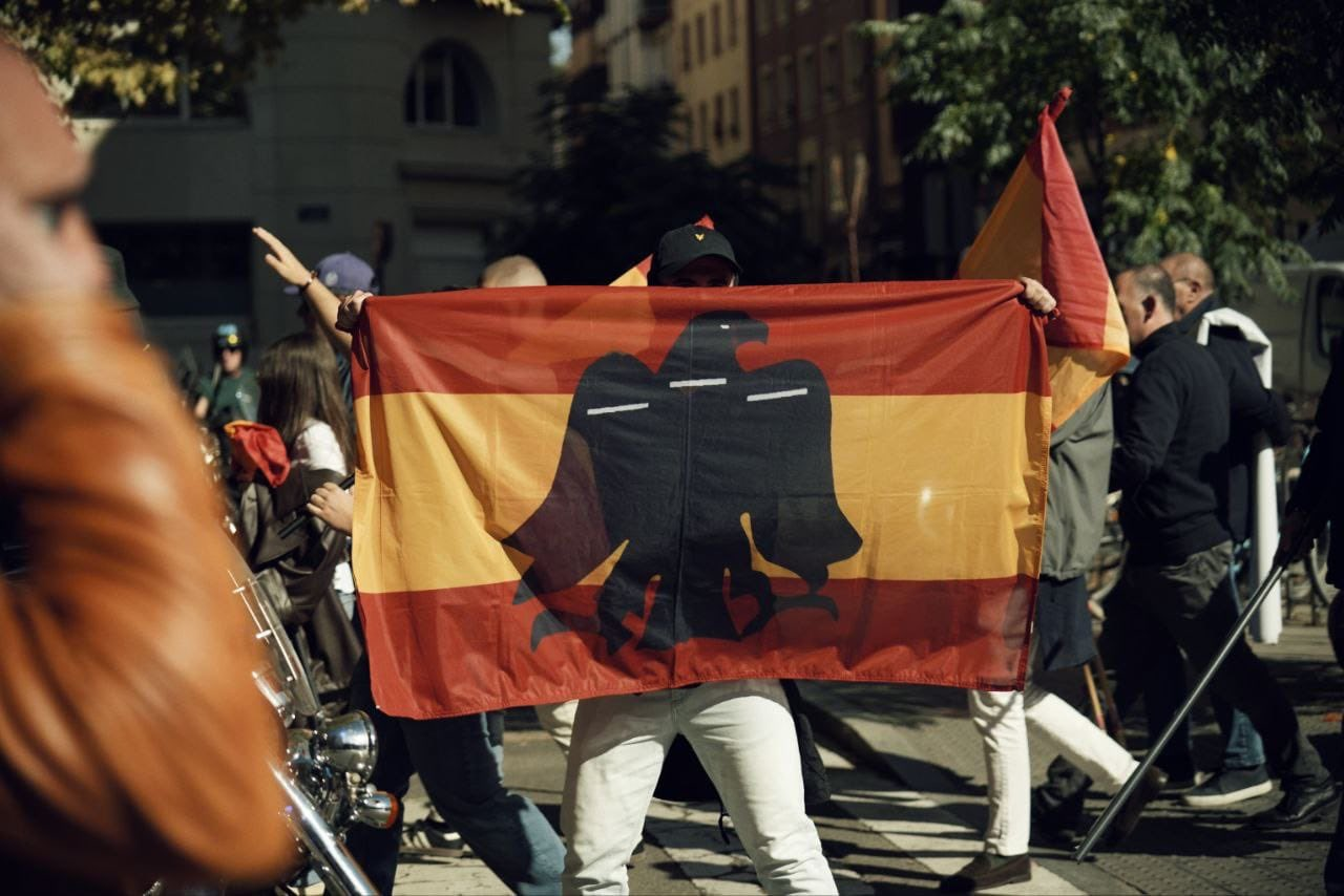 Una persona que participaba en la manifestación de Falange del domingo portando una bandera preconstitucional en el centro de Vitoria-Gasteiz.