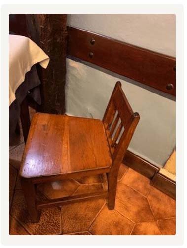 Sillas pequeñas de madera en lo que parece un restaurante tradicional, con el comentario: "Look at these tiny chairs. Woody said small back fat ass" ("Mira estas sillas diminutas. Woody dijo espalda pequeña culo gordo").