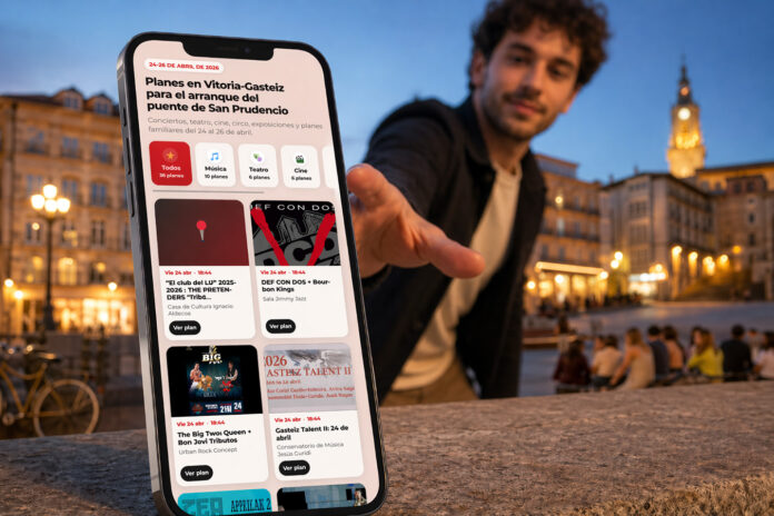 Un chico a punto de agarrar un móvil con la agenda de fin de semana de vitoria-gasteiz para este fin de semana antes de San Prudencio 2026